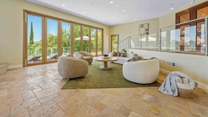 A spacious living area with a large sliding glass door leading to a balcony, a round coffee table, and two sofas.