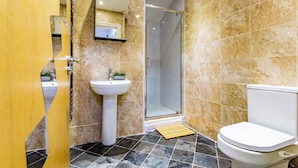 Un baño con ducha, lavamanos e inodoro.