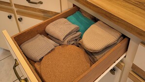 Een houten aanrecht met een lade gevuld met opgevouwen handdoeken.