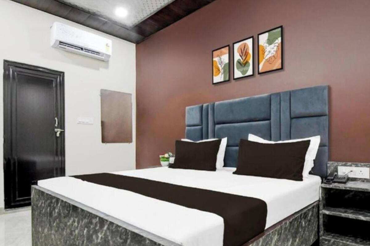 Habitación de hotel con cama, escritorio y silla. Hay un equipo de aire acondicionado en la pared.