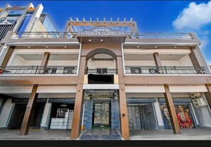 A hotel with a prominent entrance, a balcony, and a sign reading 'Evergreen Clark's Inn.' - Hotel Evergreen Clarks (Lucknow)