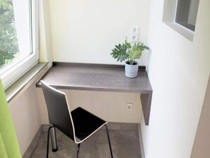 A small workspace with a desk, chair, potted plant, and a window. - 1 Person Holiday Park Home in Bendorf (Bendorf)