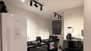 Een moderne keuken met een koelkast, fornuis, magnetron en koffiezetapparaat.