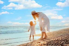 Une scène de plage avec une personne et un enfant.