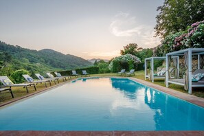 A swimming pool with lounge chairs and a gazebo, surrounded by greenery and hills. - 10 Bedroom Luxury Villa in Lucca (Lucca)