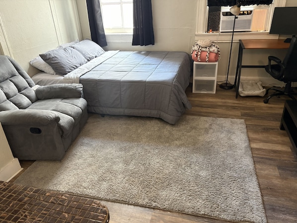 Une chambre à coucher avec un lit, un canapé, un bureau et une chaise.