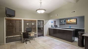 A modern kitchen with a large island, a built-in oven, and a flat-screen TV mounted above the counter.