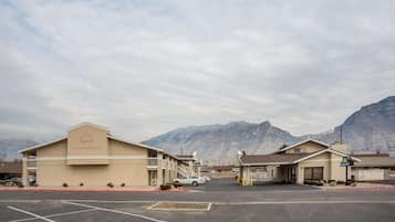 A Days Inn with a parking lot and mountainous backdrop.