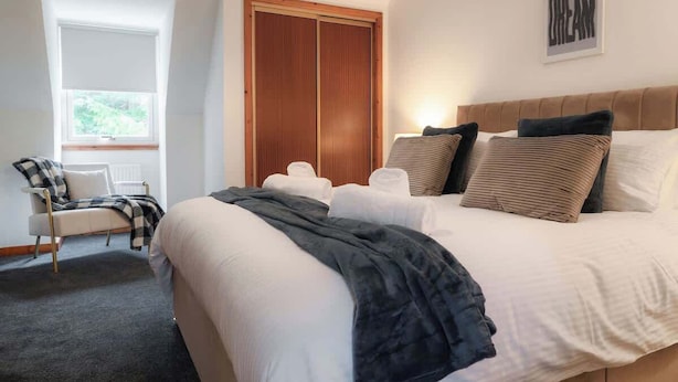 Une chambre à coucher avec un lit, une chaise, une fenêtre et une armoire.
