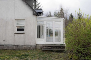 A white building with a small window and a large glass door. - Peaceful 3BR Hideaway in the Scottish Highlands (Lochbroom)