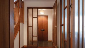 Un couloir avec des portes en bois et un sol carrelé.