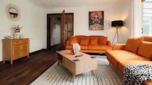 Un salon moderne avec un canapé, une table basse et des œuvres d’art accrochées au mur.