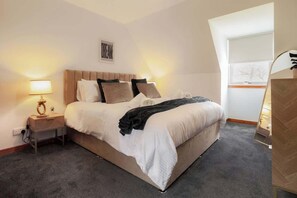 A bedroom with a bed, nightstand, lamp, and a window. - Peaceful 3BR Hideaway in the Scottish Highlands (Lochbroom)