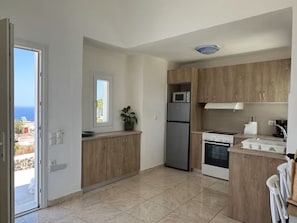 Eine moderne Küche mit Kühlschrank, Mikrowelle, Backofen und Holzschränken.