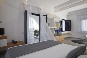 A modern bedroom with a bed, a wardrobe, a television, and a large window with a view. - Amor Hideaway Villas by Mr and Mrs White (Santorini)