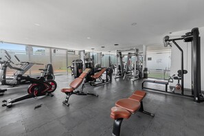 A modern gym with various exercise equipment, including treadmills, weight machines, and benches. - Stylish Zoho Skies 2-BDR, Rooftop Pool + Parking (Puerto Vallarta)