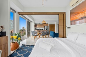 Une chambre d’hôtel moderne dotée d’un grand lit, d’un coin repas et offrant une vue sur la ville.