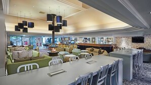 A modern lounge area with seating, a bar, and a fireplace. - Doubletree Newbury North (Newbury)