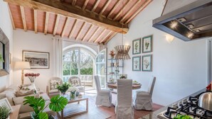 Ein gemütliches Wohnzimmer mit Kamin, ein Essbereich mit Stühlen und eine Küche mit Herd.
