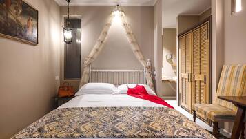 A bedroom with a canopy bed, a bedside table with a lamp, a chair, and a wardrobe.