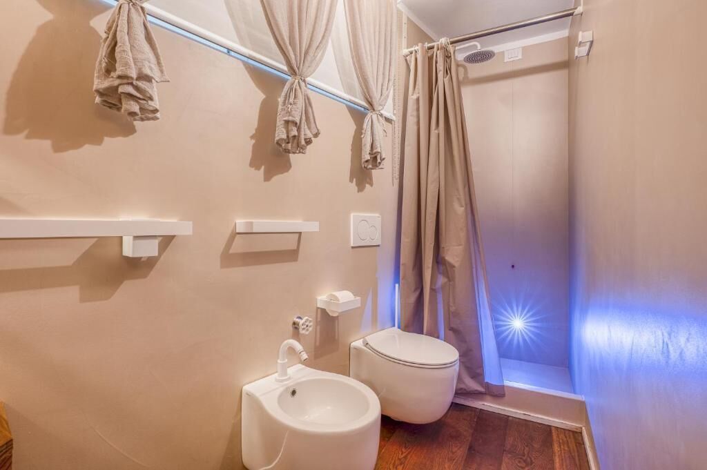 Un baño con lavamanos, inodoro y cortina de ducha.