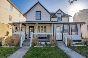 A two-story house with a front porch, a small front yard, and a garage. - Wildwood Backyard Oasis with pool (Wildwood)