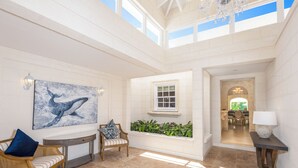 A spacious interior with a high ceiling, a dining area, and a view of the outdoors. - Royal Westmoreland Lonetrees - by Zenbreak (Westmoreland)