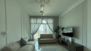 A modern living room with a sofa, TV, and a ceiling fan. - SPICE Skyview Luxe Tunas 4B3B (Bayan Lepas)