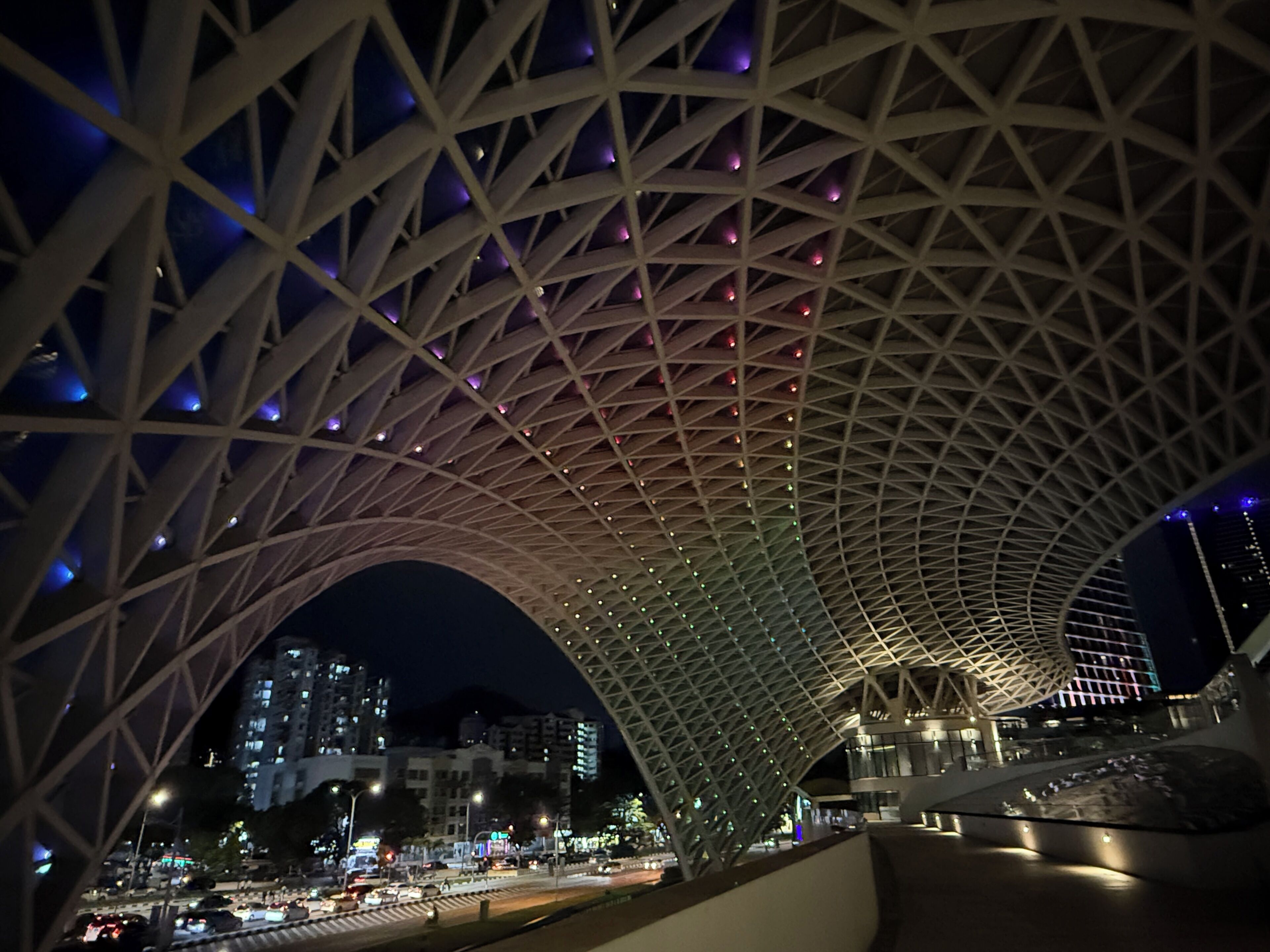 A large, arched architectural structure with a complex geometric design, likely a public building or transportation hub.