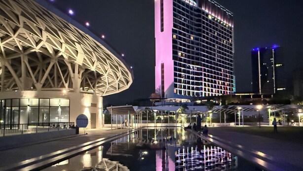 A modern hotel with a distinctive architectural design, including a large circular structure and a tall building with illuminated windows. - SPICE Skyview Luxe Tunas 4B3B (Bayan Lepas)