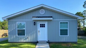 A single-story building with a front door, two windows, and a small porch. - New Build, Modern Studio. Minutes from the Beach. (Navarre)