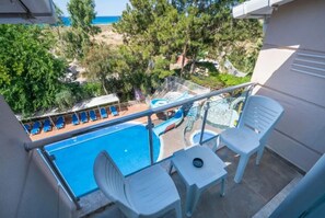 A balcony with a pool, chairs, and a table. - Club Aperion Beach Hotel (Manavgat)
