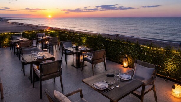 An outdoor dining area with tables and chairs, overlooking a beach at sunset. - Club Aperion Beach hotel - All inclusive (Manavgat)