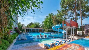 A swimming pool with a water slide, lounge chairs, and a lifeguard tower. - Club Aperion Beach hotel - All inclusive (Manavgat)