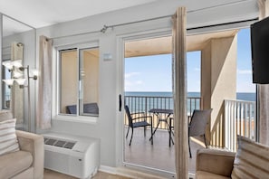 Un balcon avec vue sur la mer, une table, des chaises et un canapé.