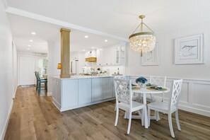 A modern kitchen with white cabinetry, a central island, and a chandelier. - Luxury Waterfront Escape Near St. Pete Beach & Pass-a-Grille | Isla Del Sol Paradise (Isla Del Sol)