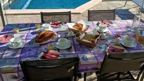 A table set outdoors with a pool in the background. - Bed and breakfast with swimming pool (Trausse)