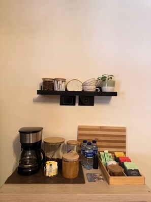 Eine Kaffeestation mit Kaffeemaschine, Gläsern und Teebeuteln.