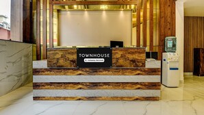 A reception desk with a marble top, a sign reading 'TOWNHOUSE Company-Serviced,' and a water dispenser. - Classic Madgaon (Margao)