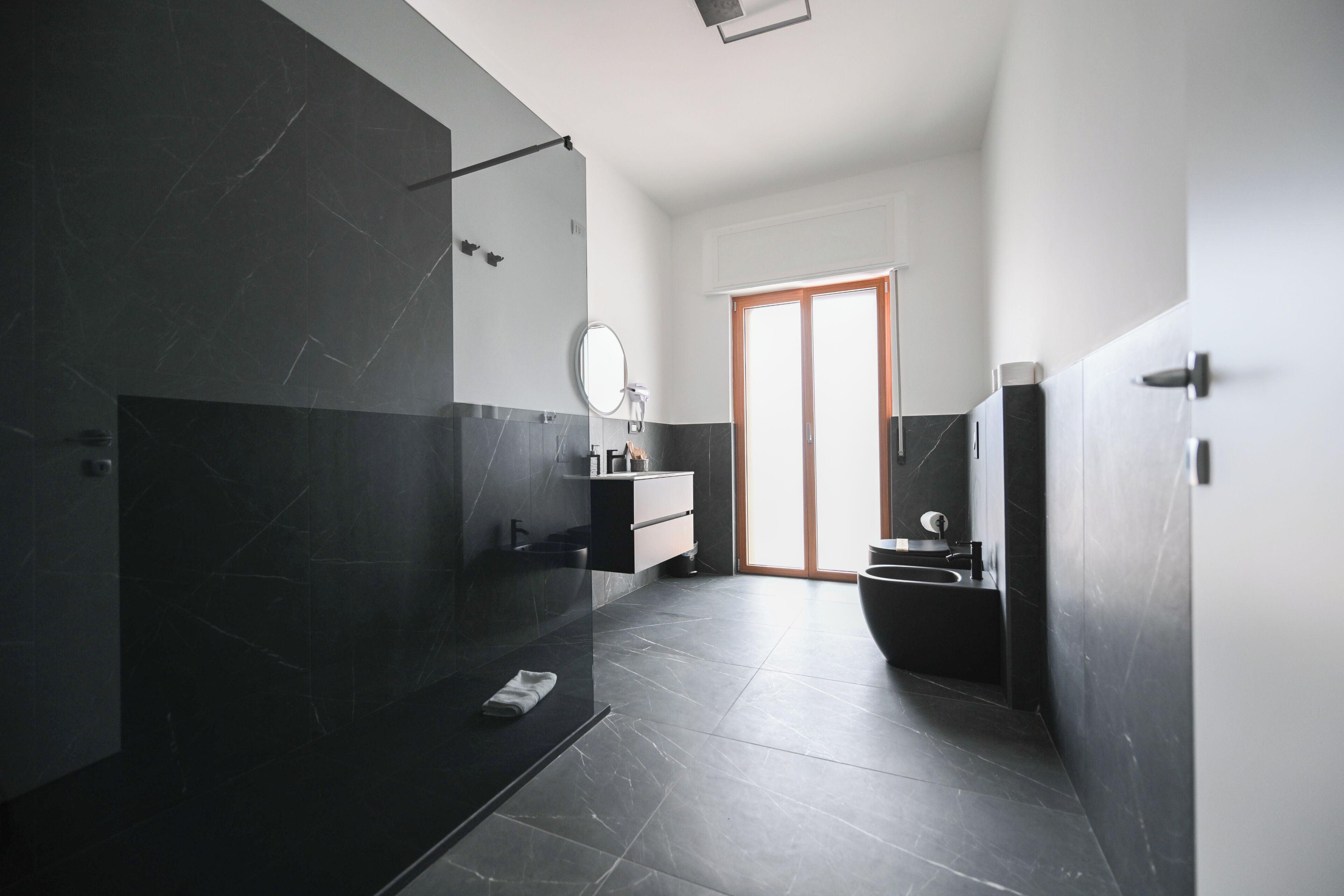 A modern bathroom with a glass shower enclosure, a vanity with a mirror, and a toilet.