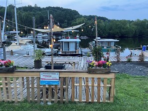 A dock with houseboat parking, surrounded by boats and greenery.