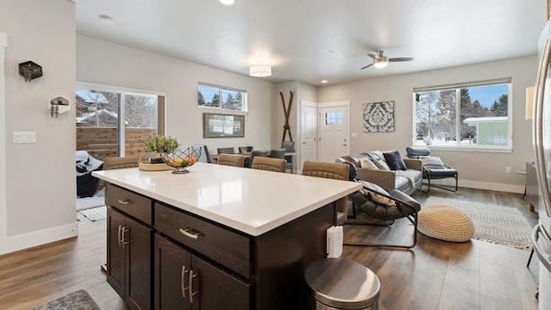 A spacious living area with a large central island, dark wood cabinets, and a ceiling fan. - Newly Listed Dog Friendly Townhouse Near Downtown Whitefish (Whitefish)