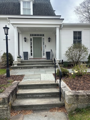 A two-story house with a front porch, a green door, and a mailbox. - Beautiful 5-bedroom residence  with private dock on Captains Row in Mystic, Ct (Mystic)