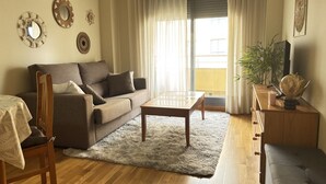 Een woonkamer met een bank, salontafel en een eethoek met een stoel en tafel.