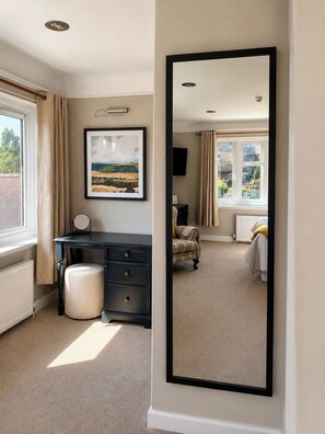 A room with a desk, a chair, a radiator, a window with curtains, and a framed picture on the wall. - Raven Suite - 4 | Central Location (Shropshire)