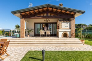 A house with a patio, outdoor seating, a fireplace, and a pool. - Villa in Viareggio Near Lecciona Beach (Viareggio)