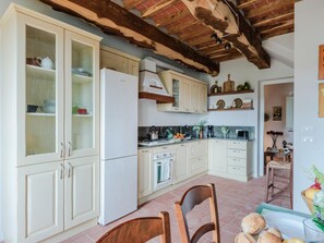 Una cocina con armarios blancos, estufa y refrigerador.