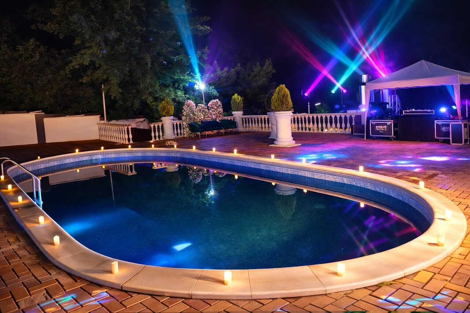 A pool with a white edge, surrounded by a brick patio.