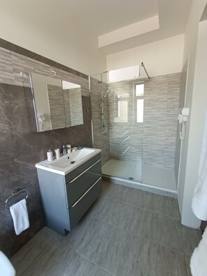 A modern bathroom with a glass-enclosed shower, a vanity with a mirror, and a towel rack. - Virginia Gardens  (Baile Govora)