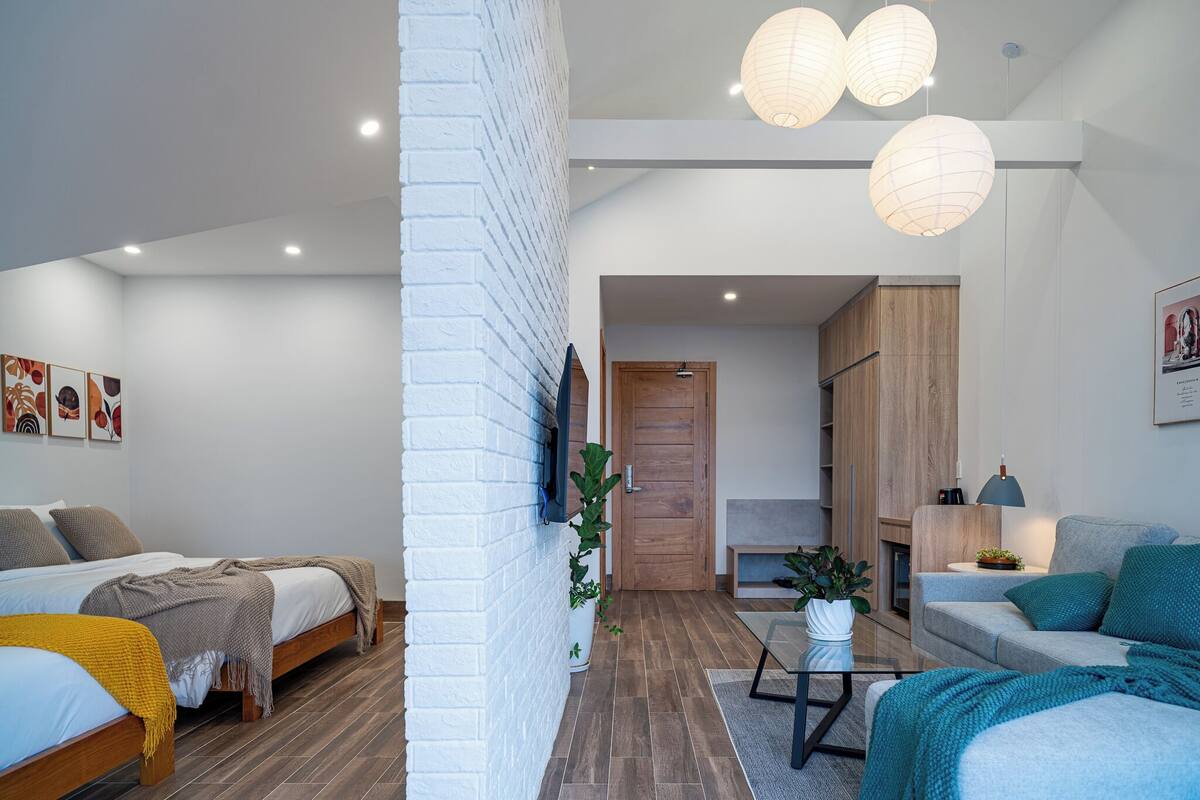 Una sala de estar moderna con un sofá, una mesa de centro y un televisor montado en la pared.